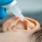 ear drops being dripped into ear